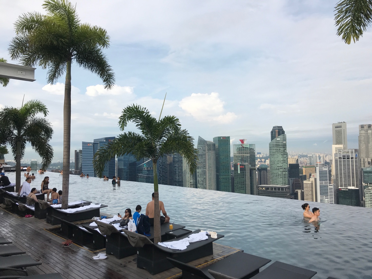 a pool with people on it and a city skyline in the background