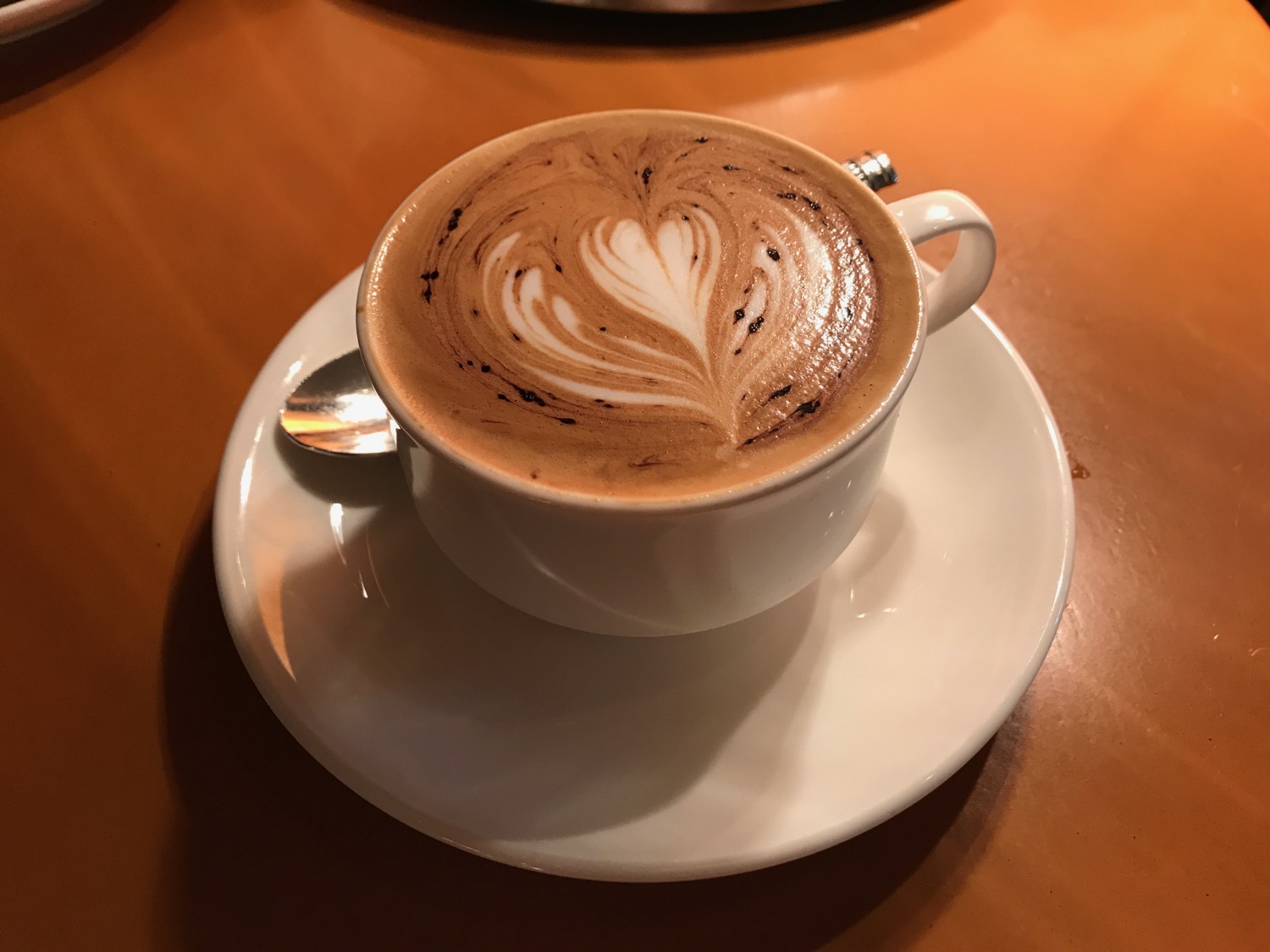 a cup of coffee with a heart design in the foam