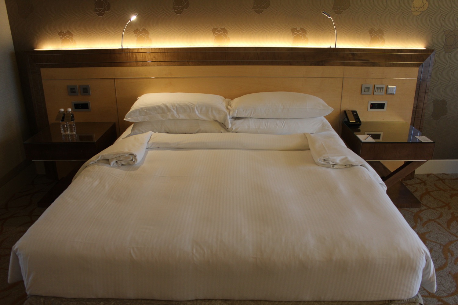a bed with white sheets and pillows