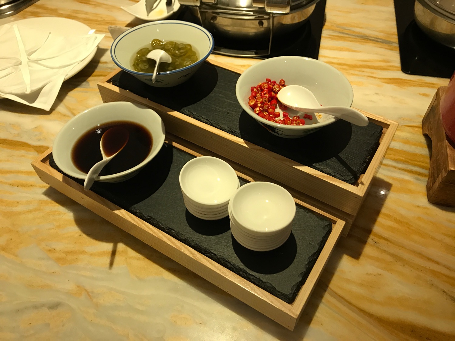 a tray of bowls with sauces and bowls of food