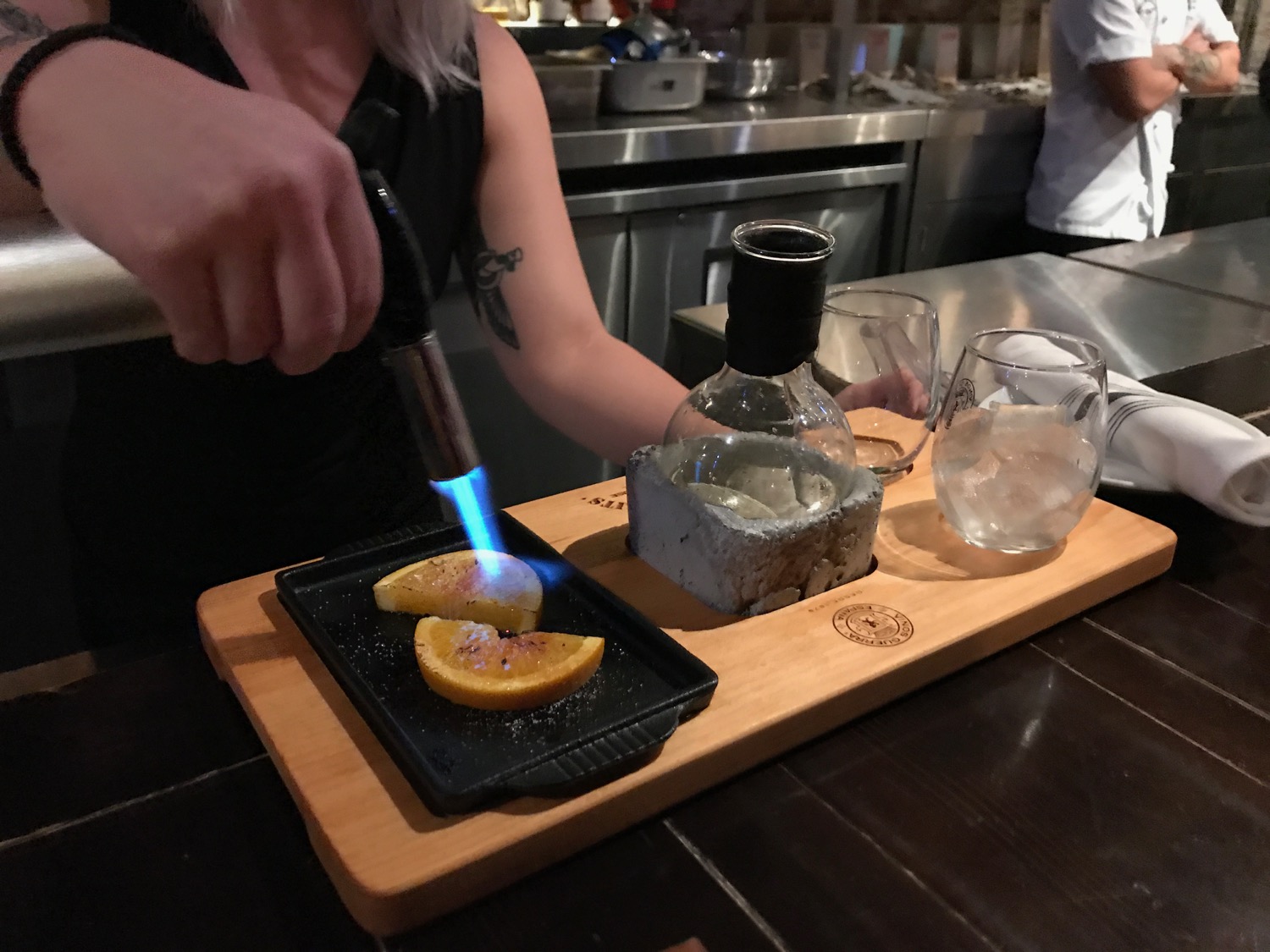 a person lighting a piece of food on a cutting board
