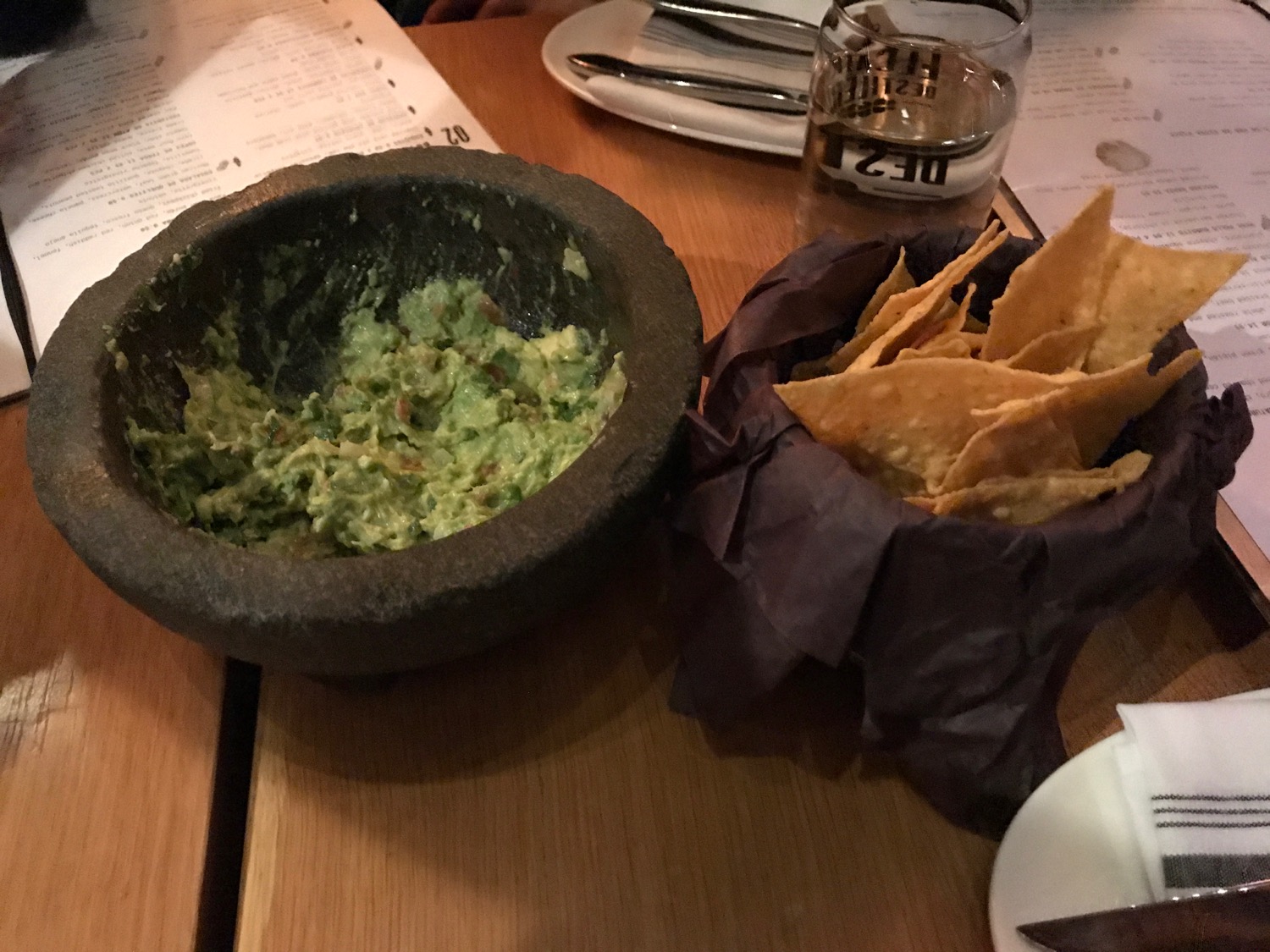 a bowl of guacamole and chips on a table