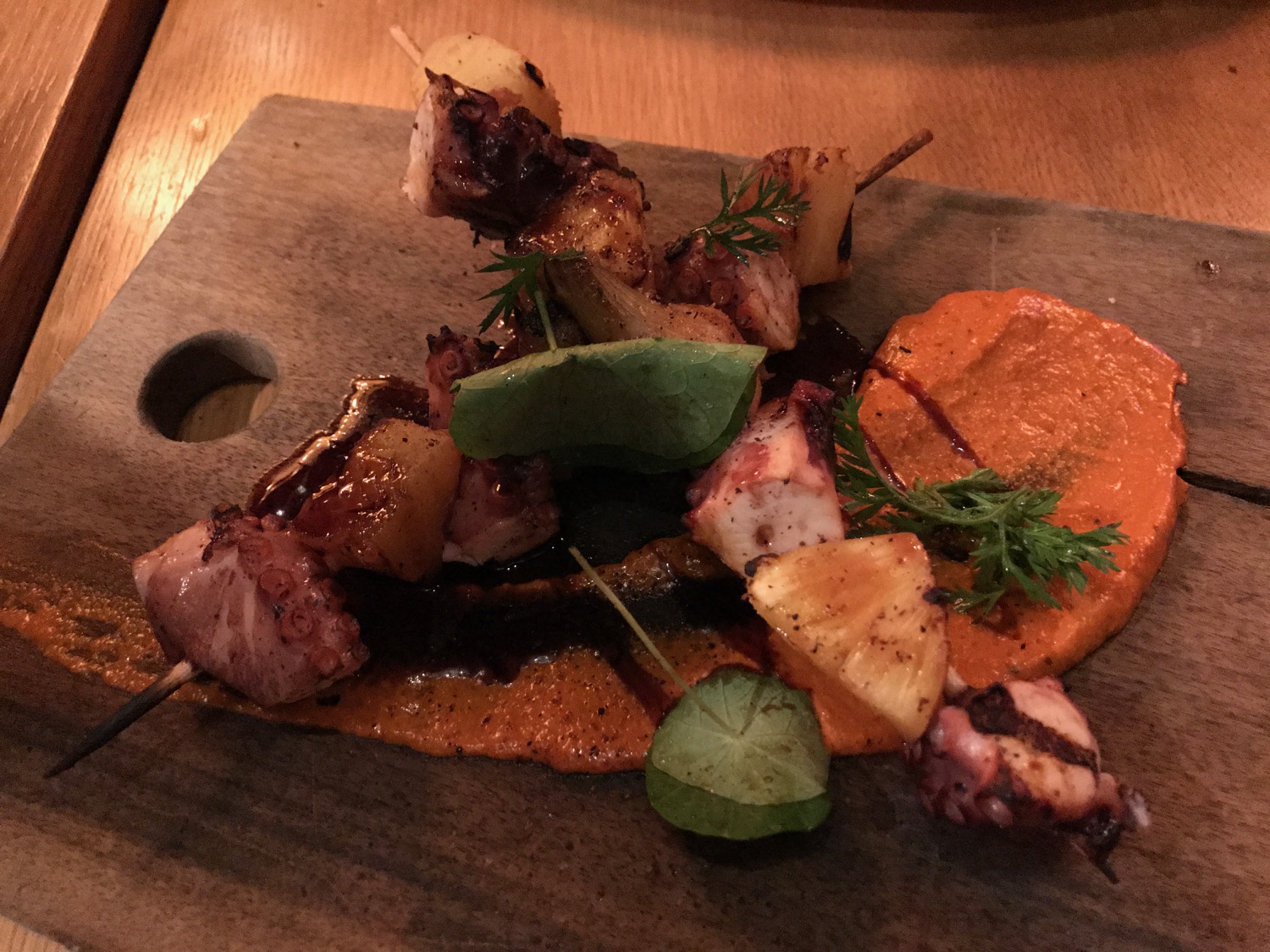 a skewer of meat and vegetables on a wooden board