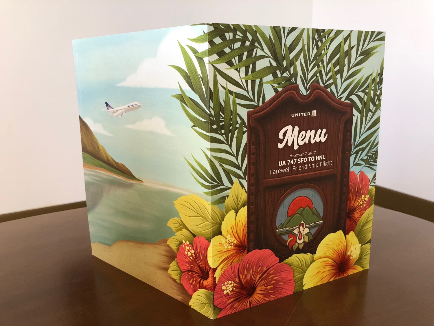 a menu box with flowers and an airplane flying in the sky