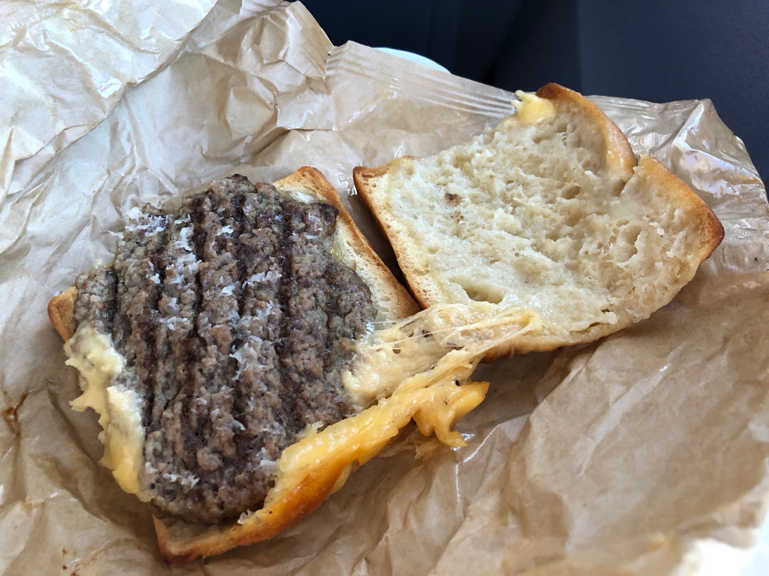 a burger cut in half on a brown paper