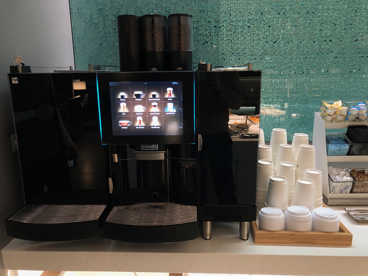 a machine with a screen and cups on a table