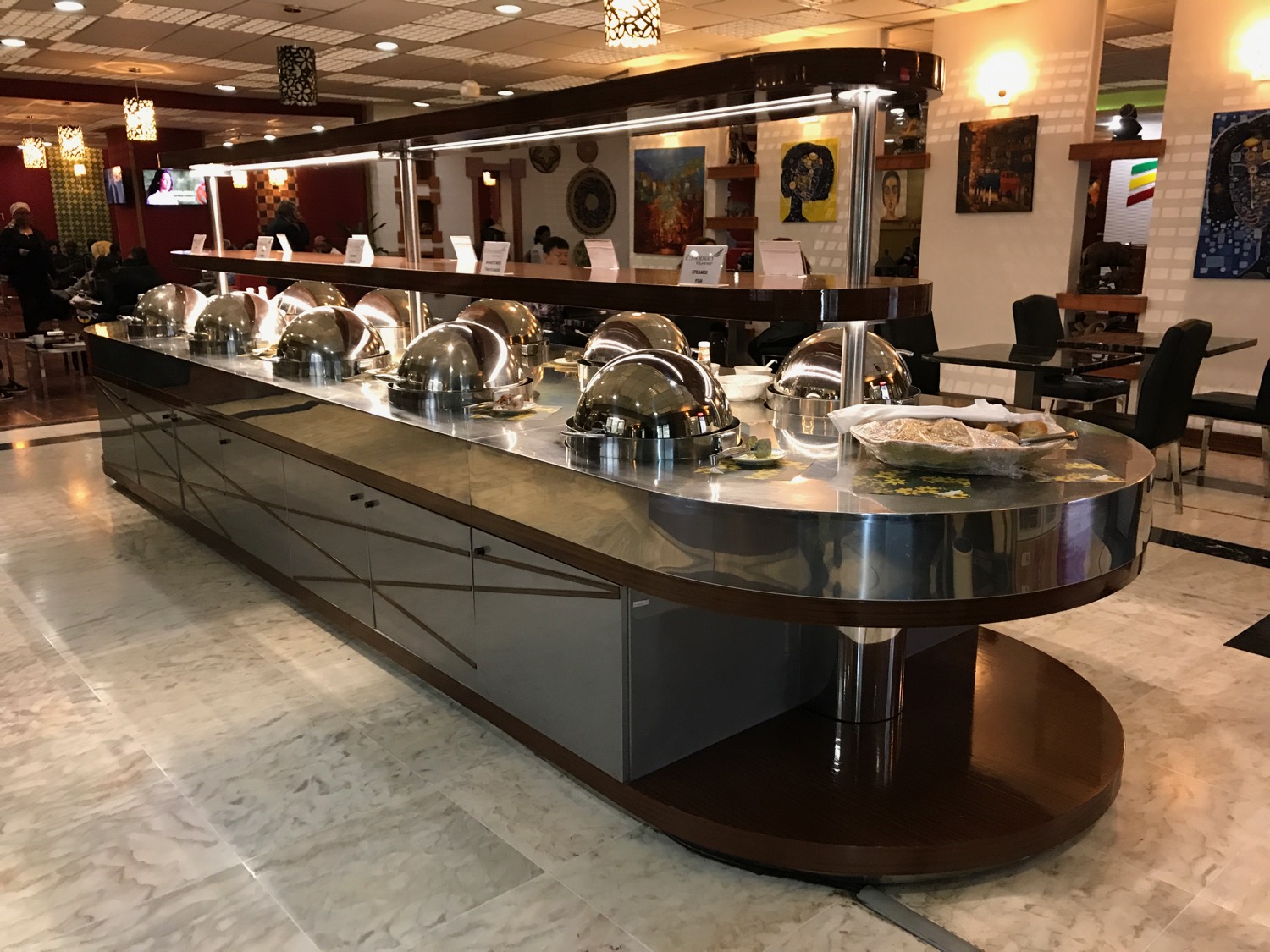 a buffet line with silver bowls on top