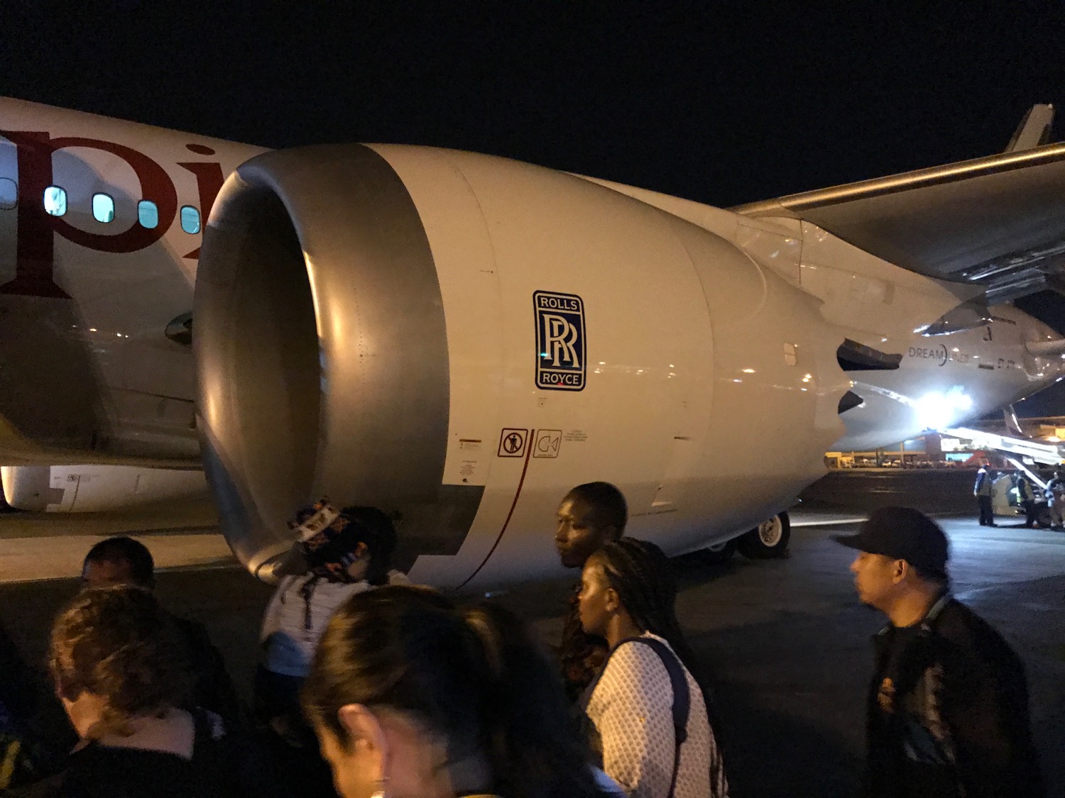 people standing around a large white airplane