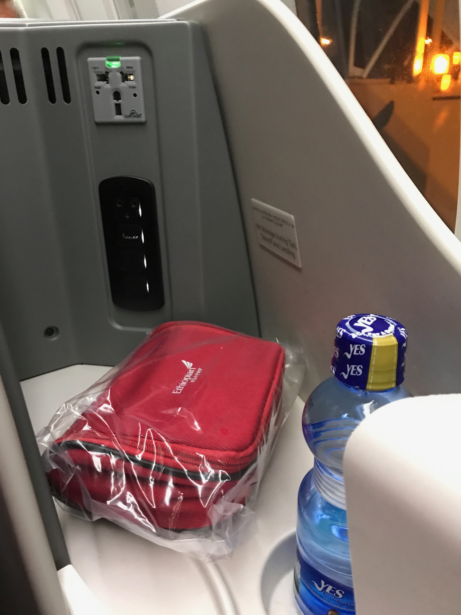 a red bag and a bottle of water on a seat