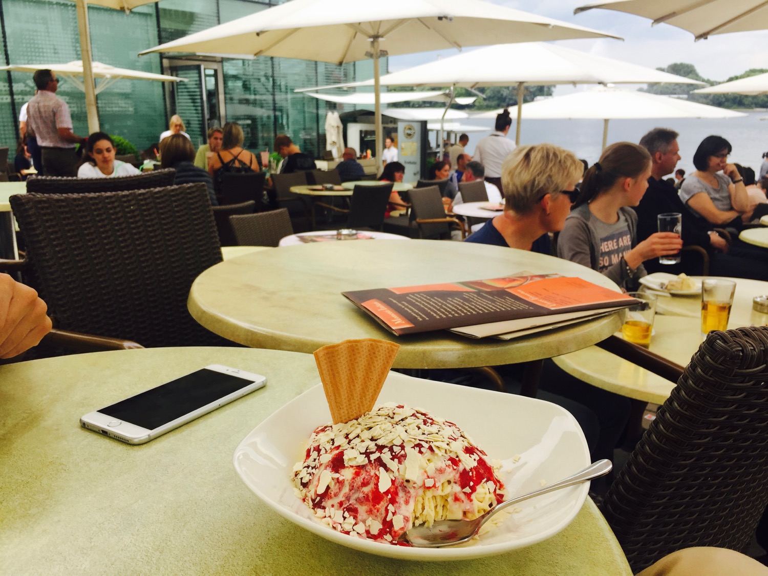 a plate of ice cream on a table with people sitting at tables