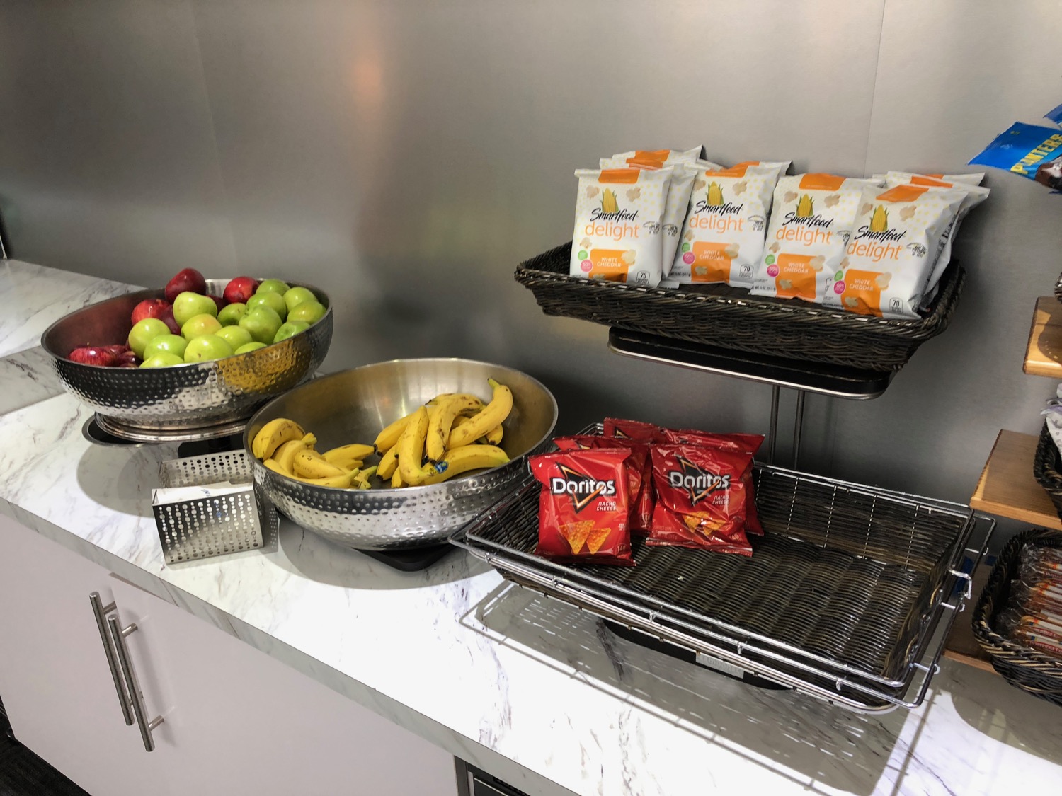 a group of bowls of fruit and chips on a counter