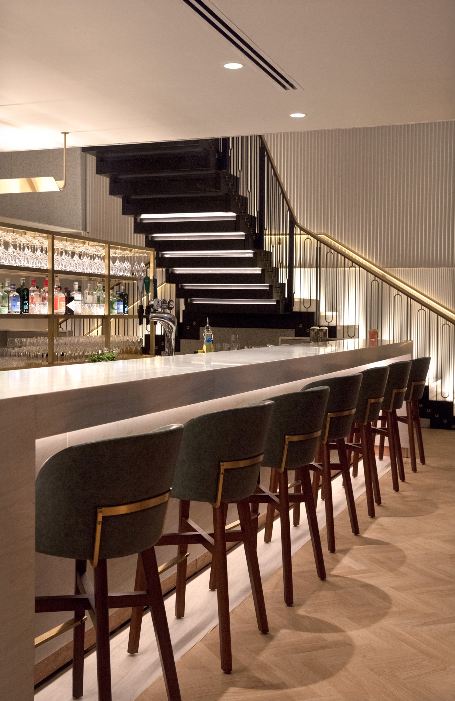 a bar with chairs and a staircase