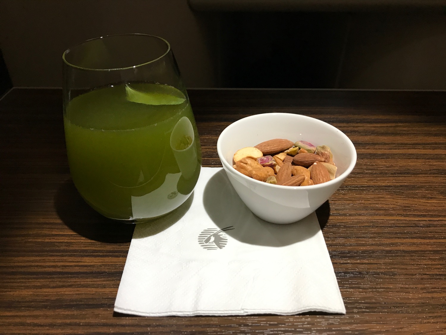 a bowl of nuts and a glass of green liquid
