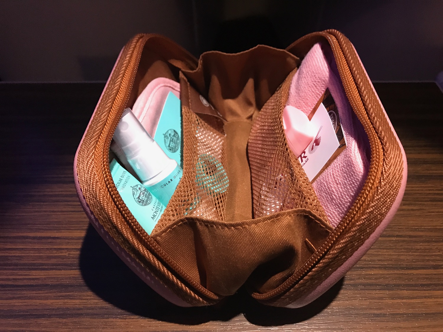 a small pink pouch with a small spray bottle inside