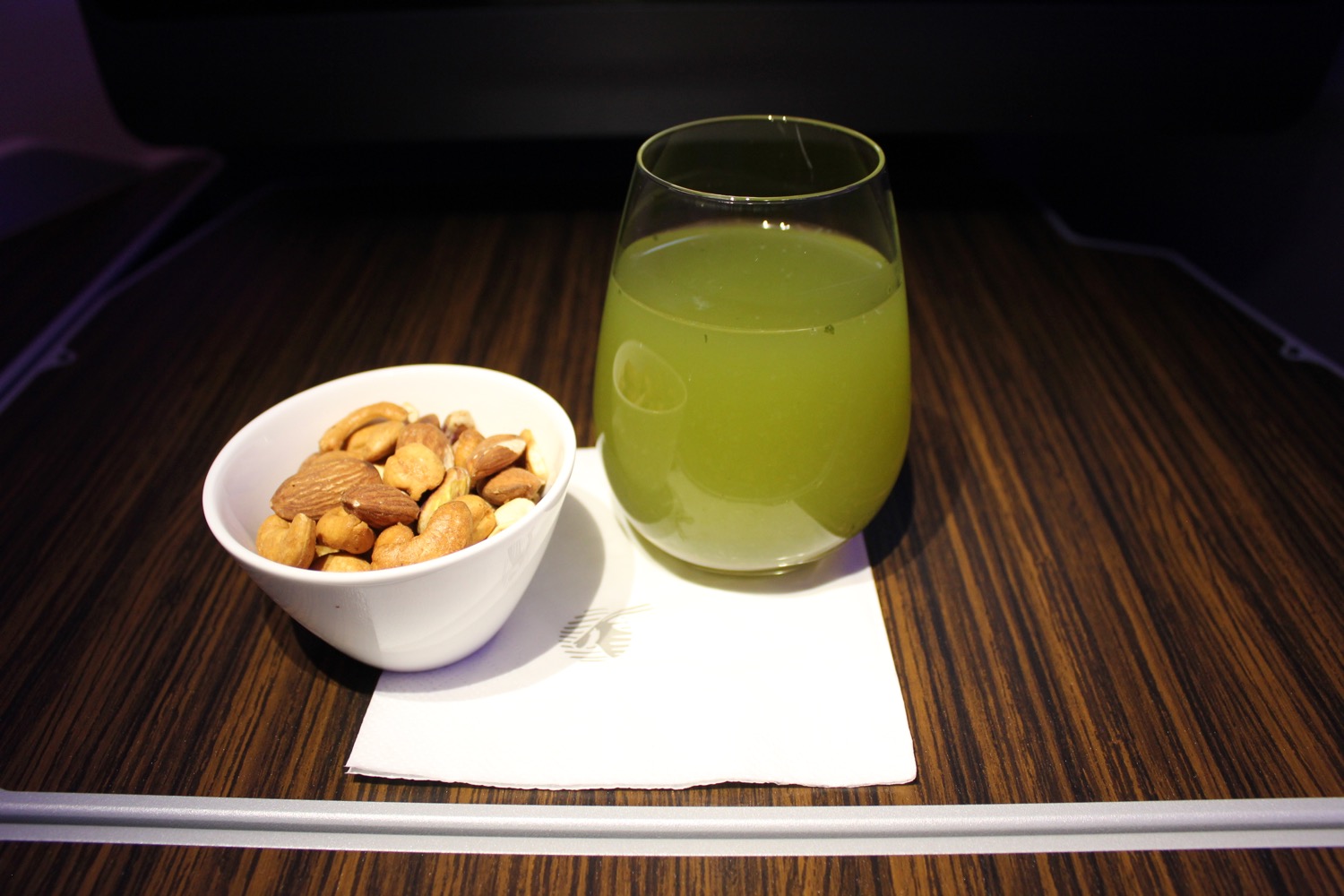 a bowl of nuts and a drink on a table