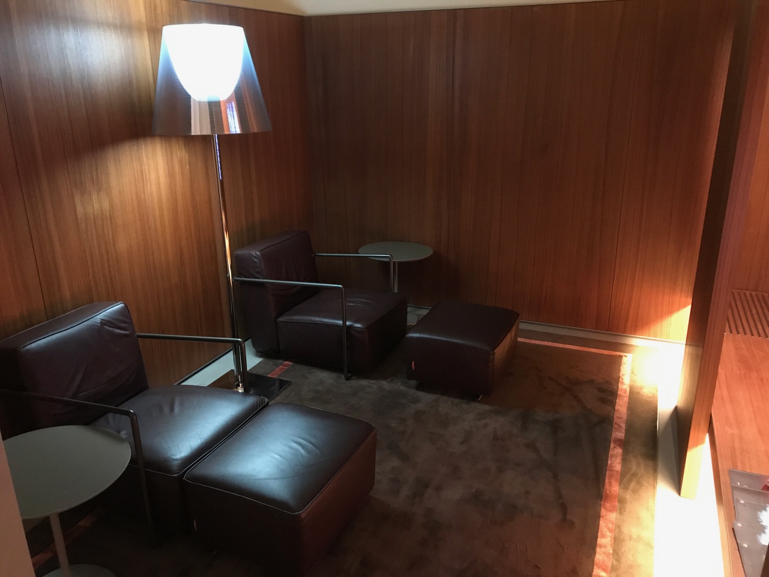 a room with a lamp and leather chairs