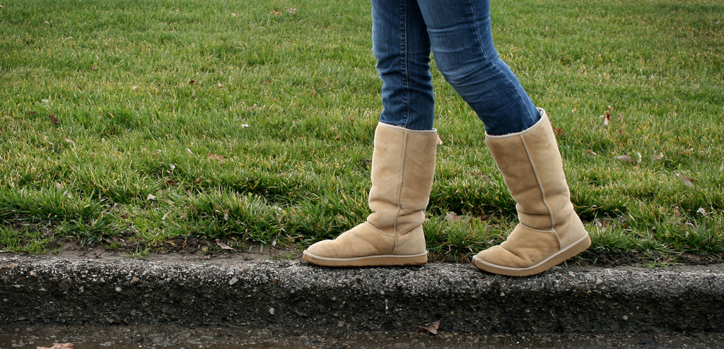 a person wearing boots walking on a curb