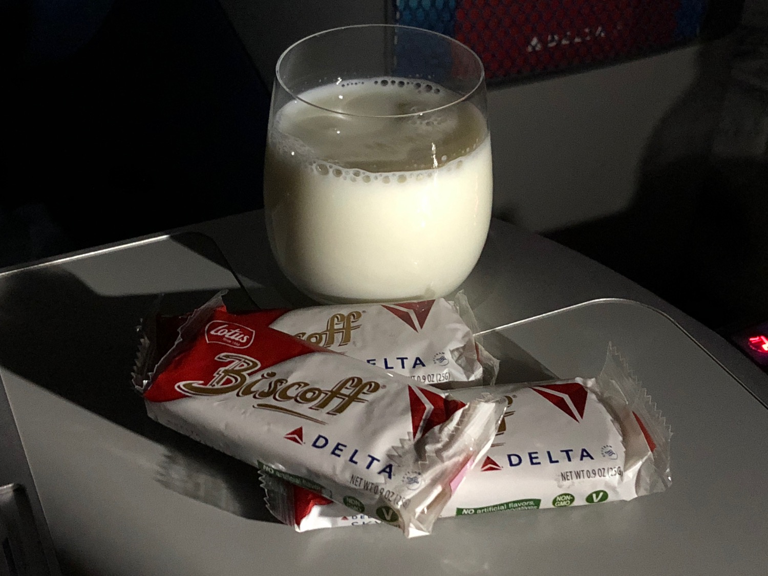 a glass of milk and some packages of cookies