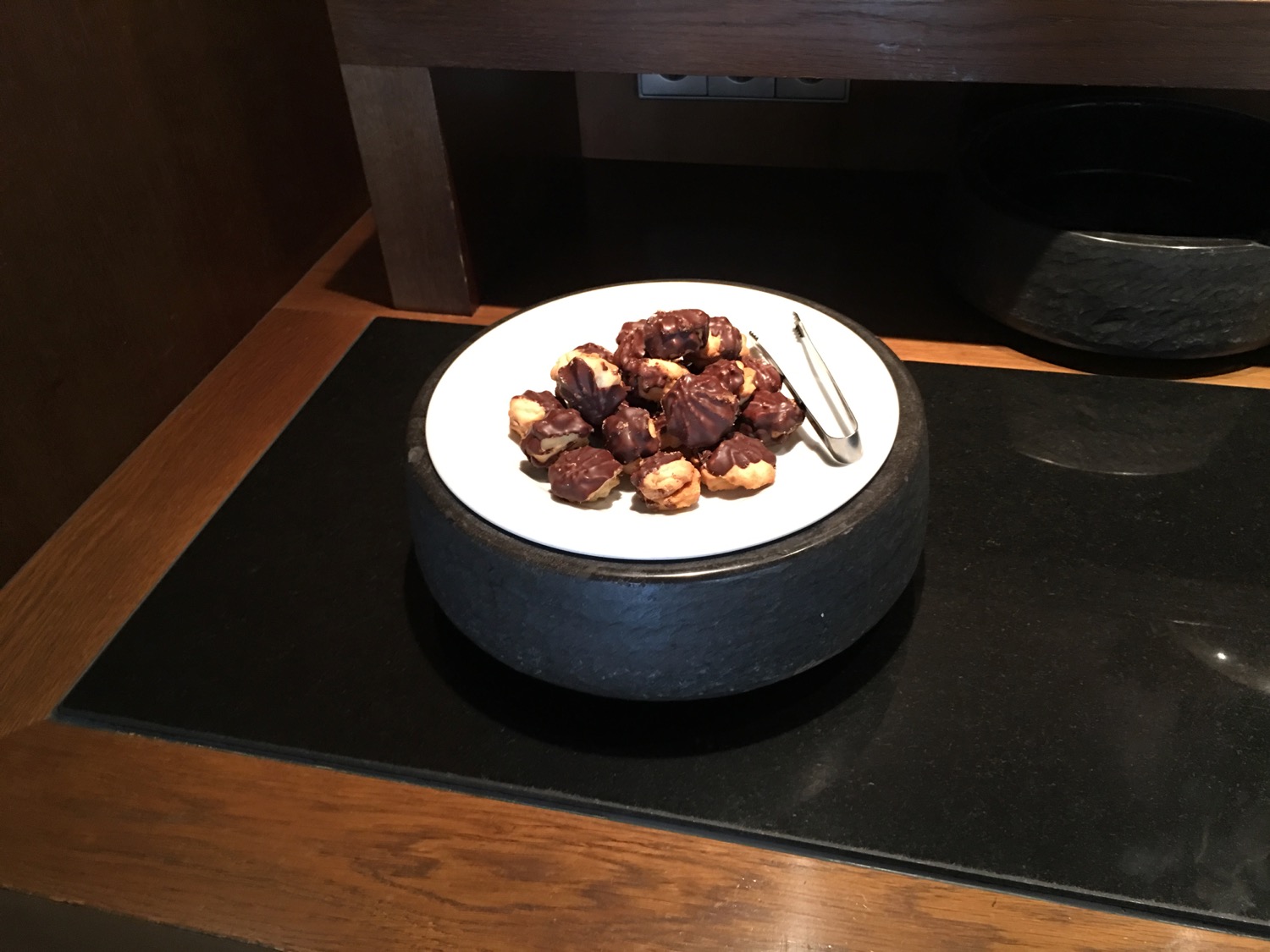 a plate of chocolate covered nuts on a black surface
