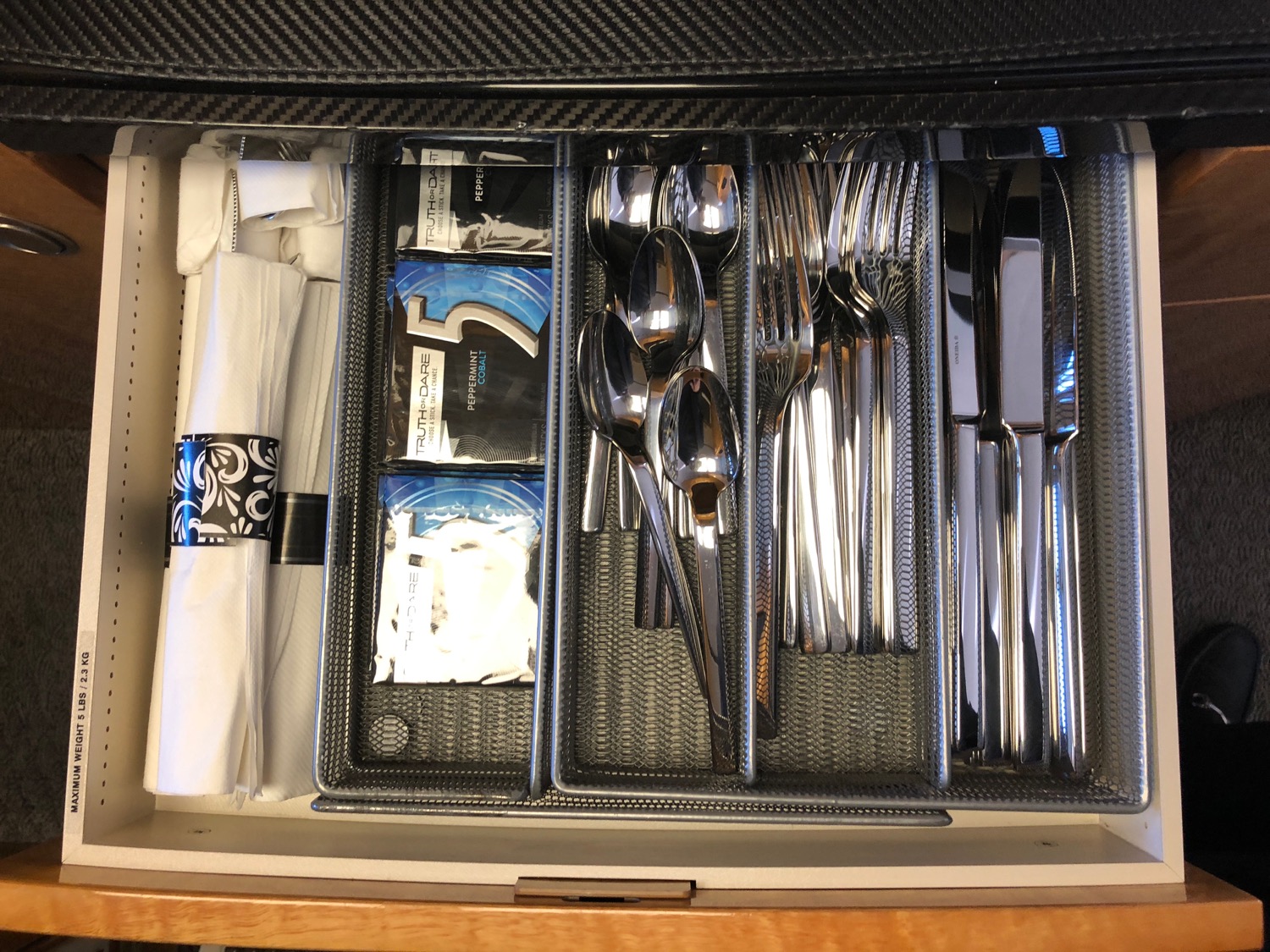 a drawer with silverware and napkins
