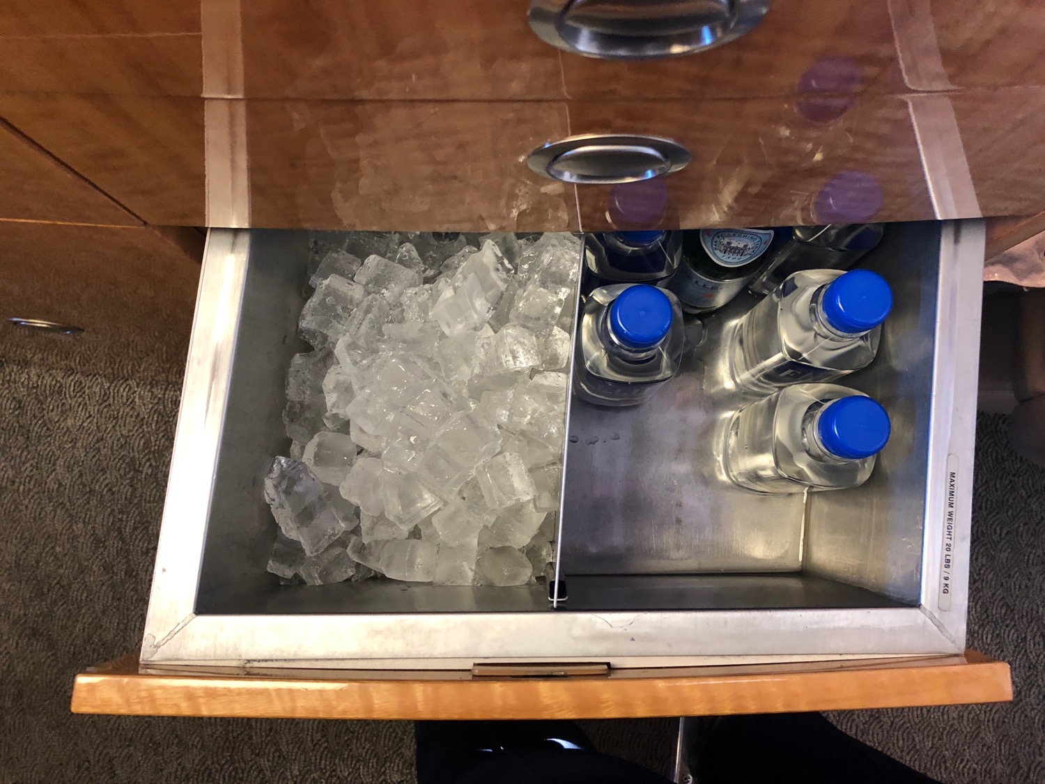 a drawer with ice cubes and bottles in it