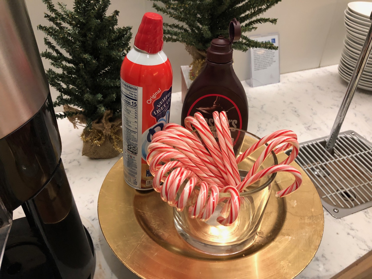 a glass with candy canes on a gold plate with a bottle of cleaner