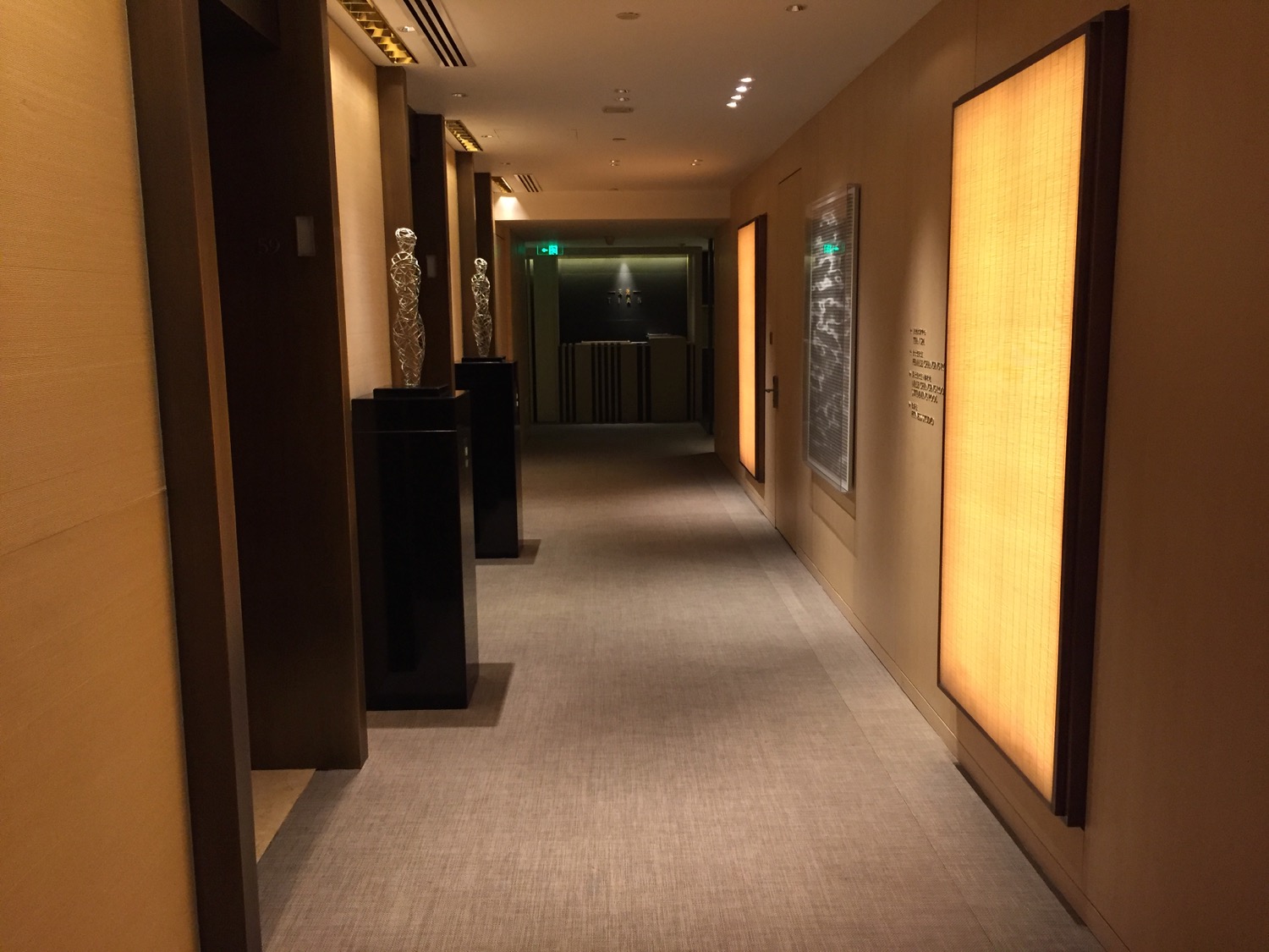 a hallway with a few sculptures on the walls