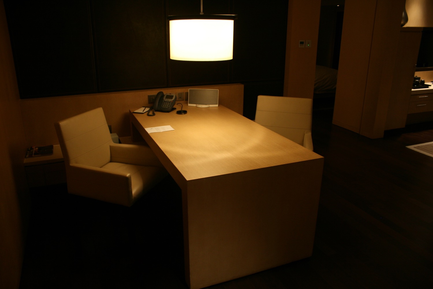 a desk with a lamp and chairs