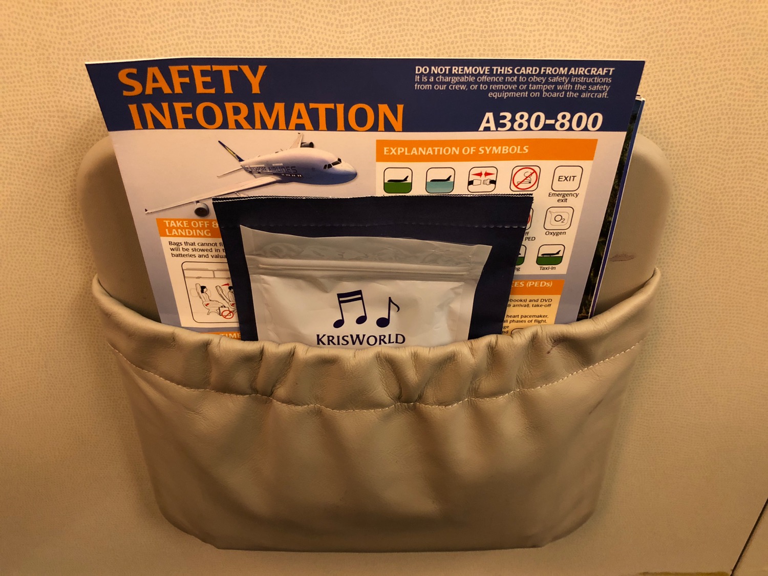 a seat pocket with a safety information and a packet