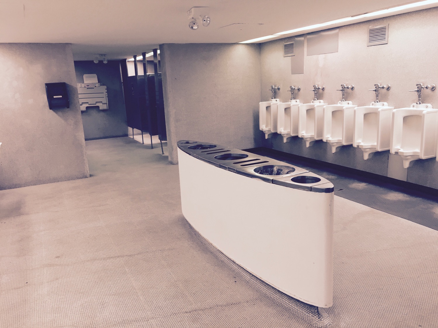 a bathroom with urinals and a wall