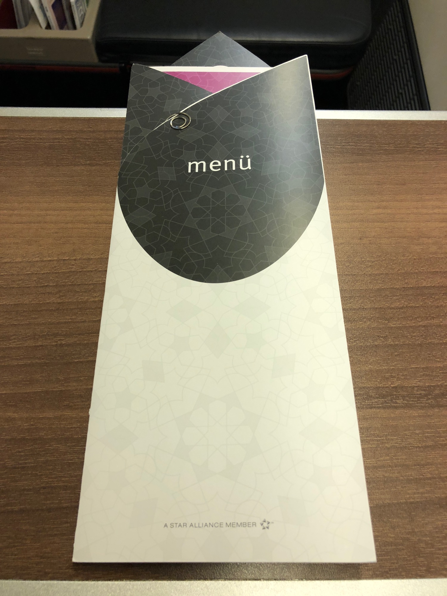 a white and black menu box on a wood surface