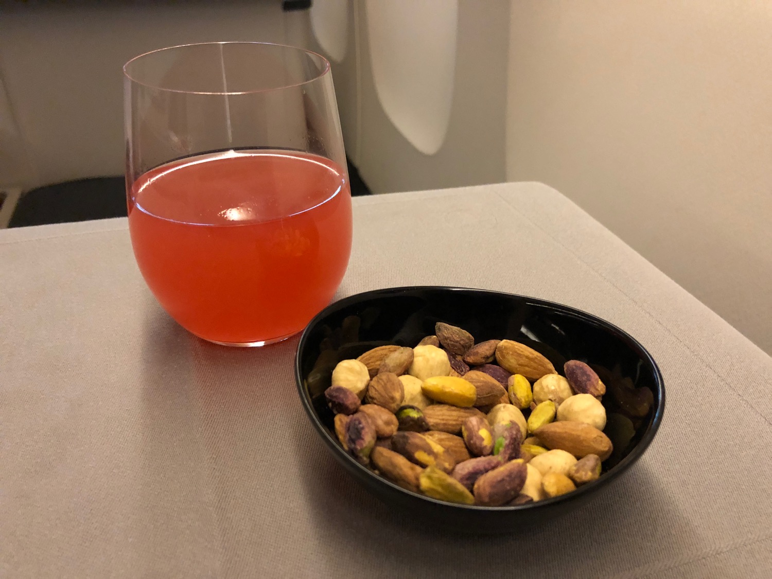 a bowl of nuts and a glass of juice