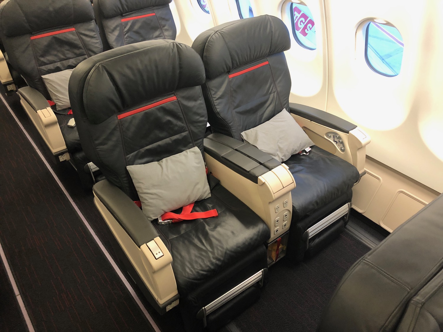 a row of black leather seats on an airplane