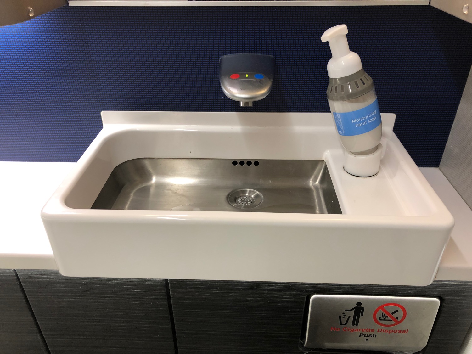 a sink with soap dispenser and a bottle of liquid