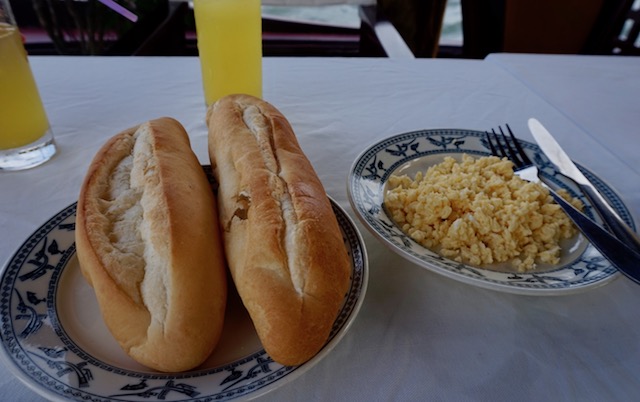 Scrambled eggs, fresh bread served with butter, jam and pineapple juice