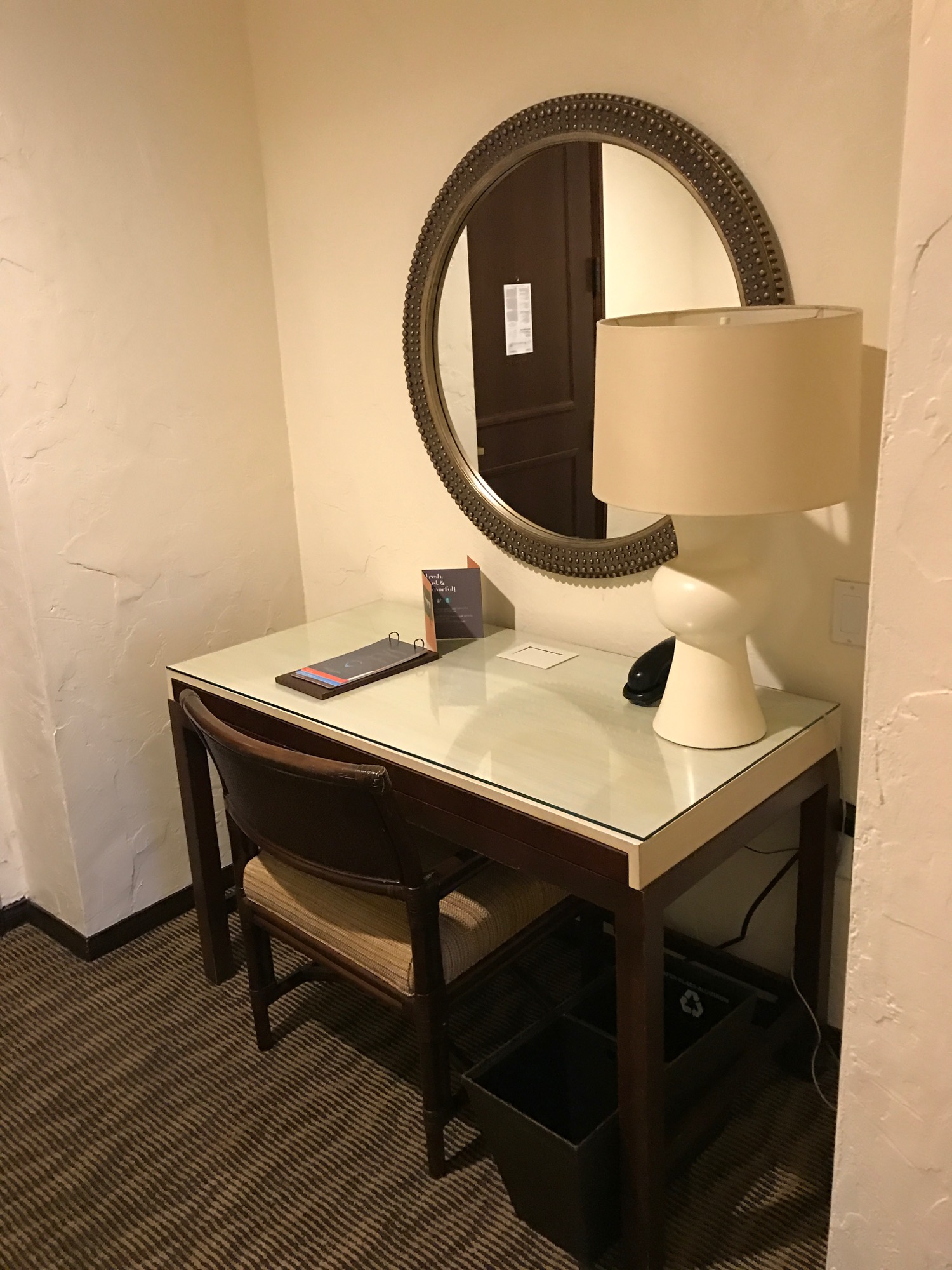 a desk with a lamp and a mirror