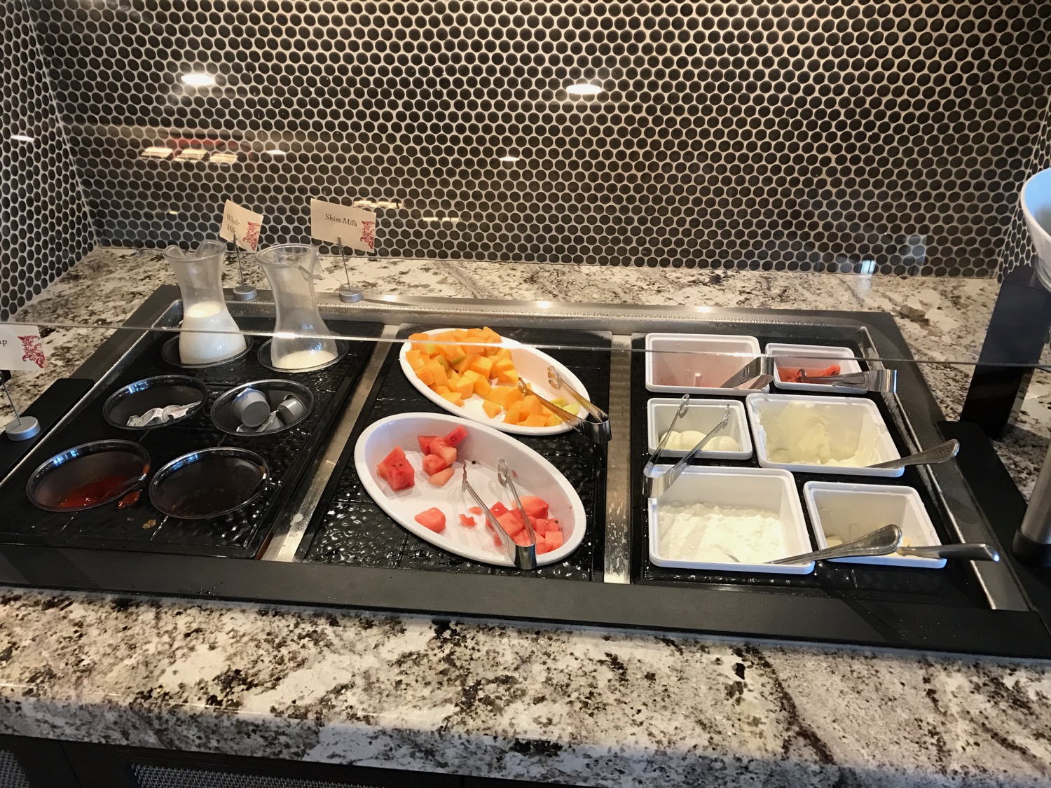 a trays of fruit and yogurt on a counter