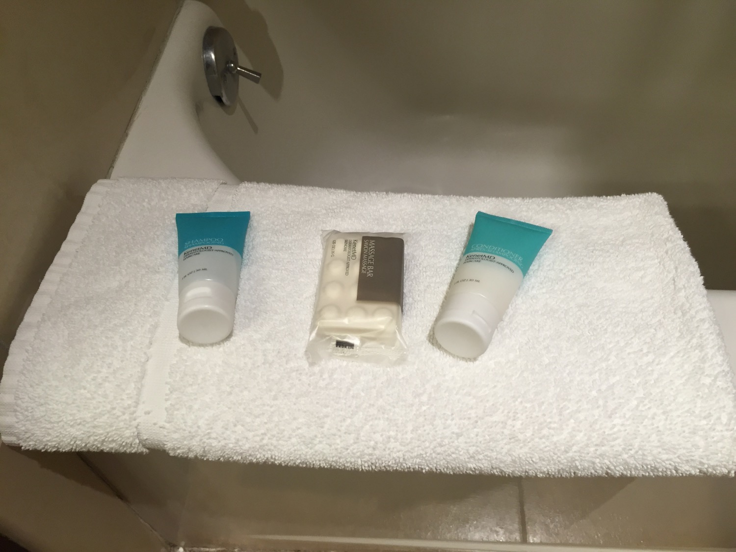 a bathtub with a towel and a few bottles of shampoo and soap