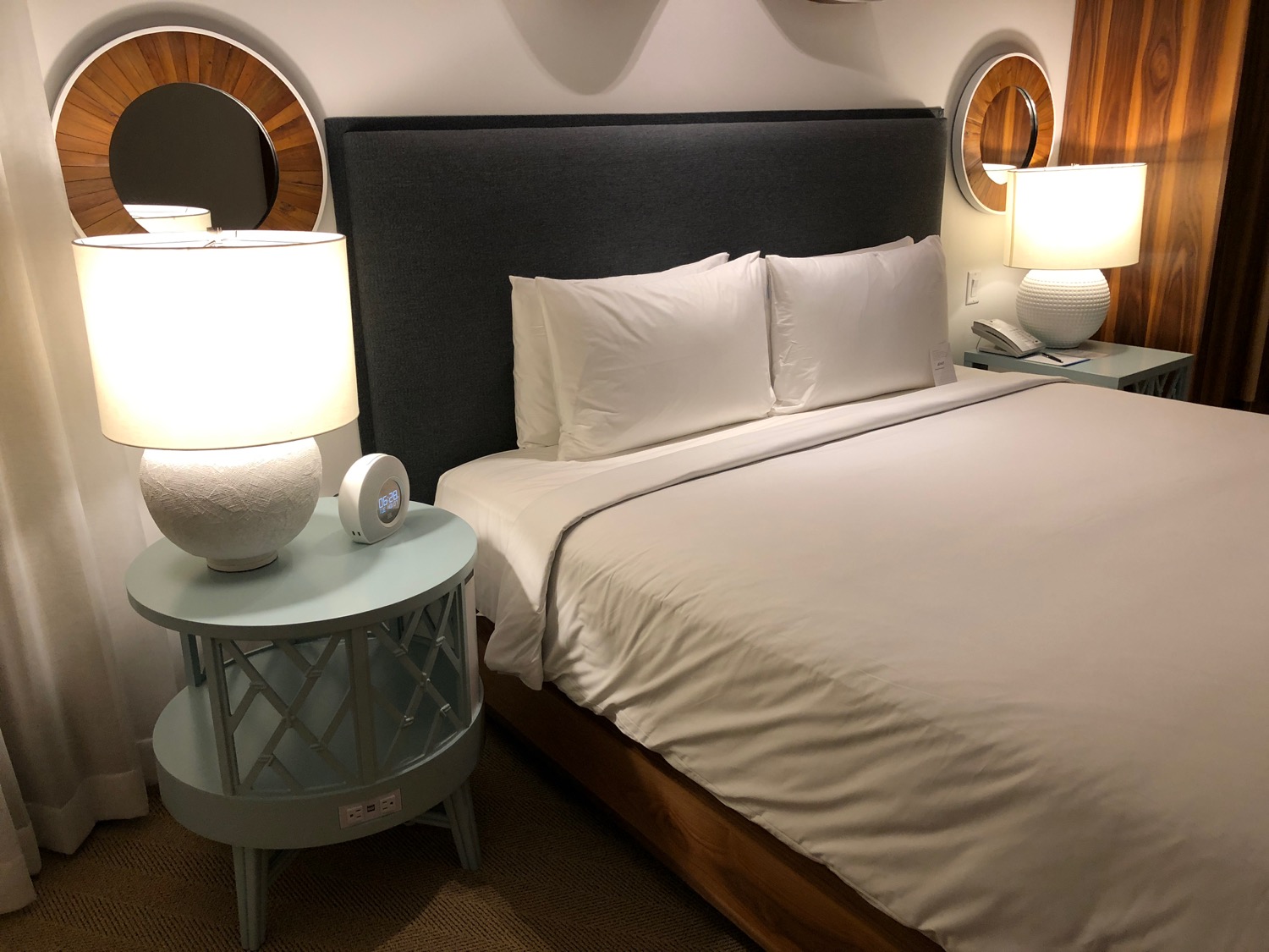 a bed with a round table and lamps
