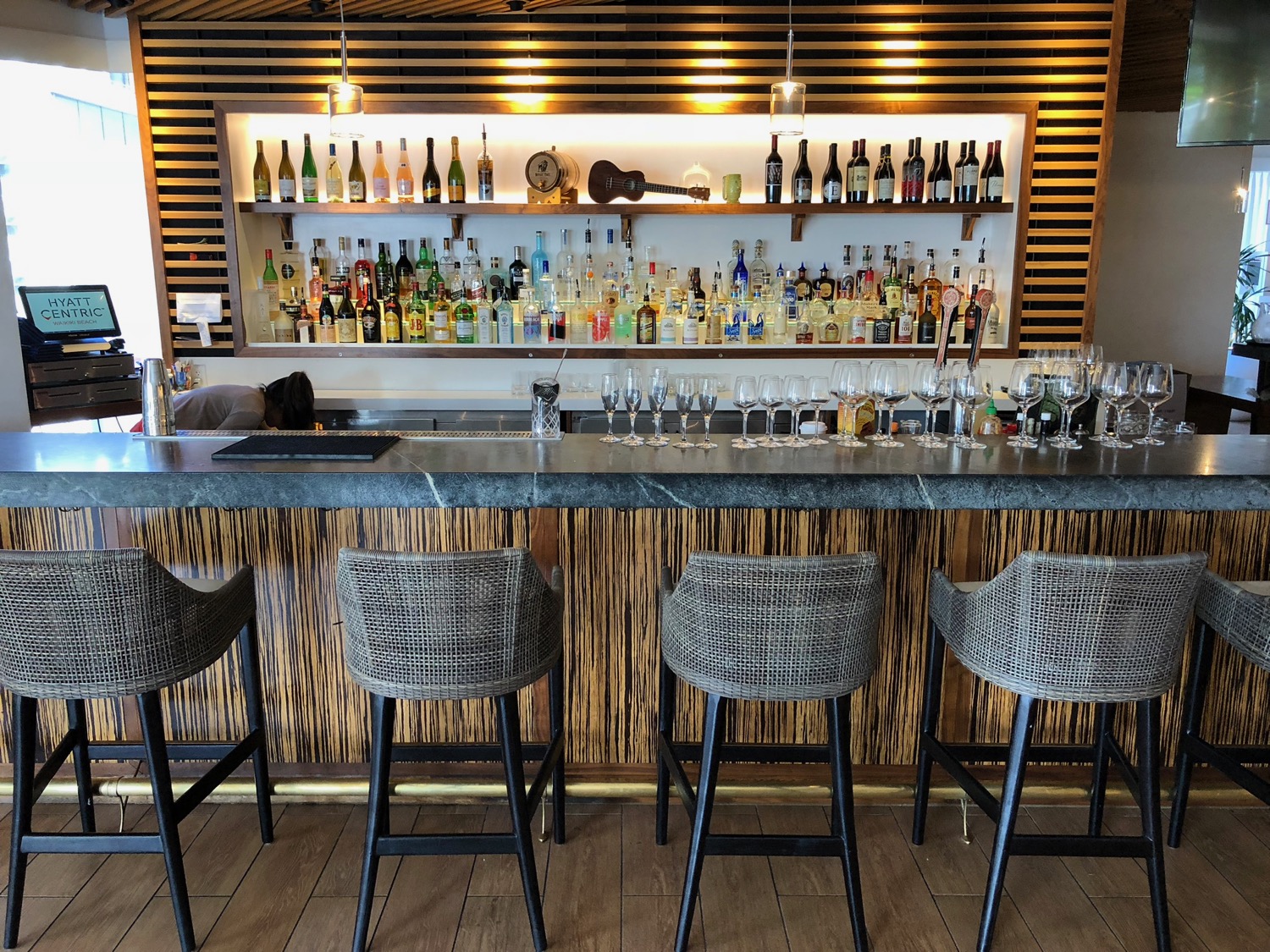 a bar with many glasses and bottles on the wall