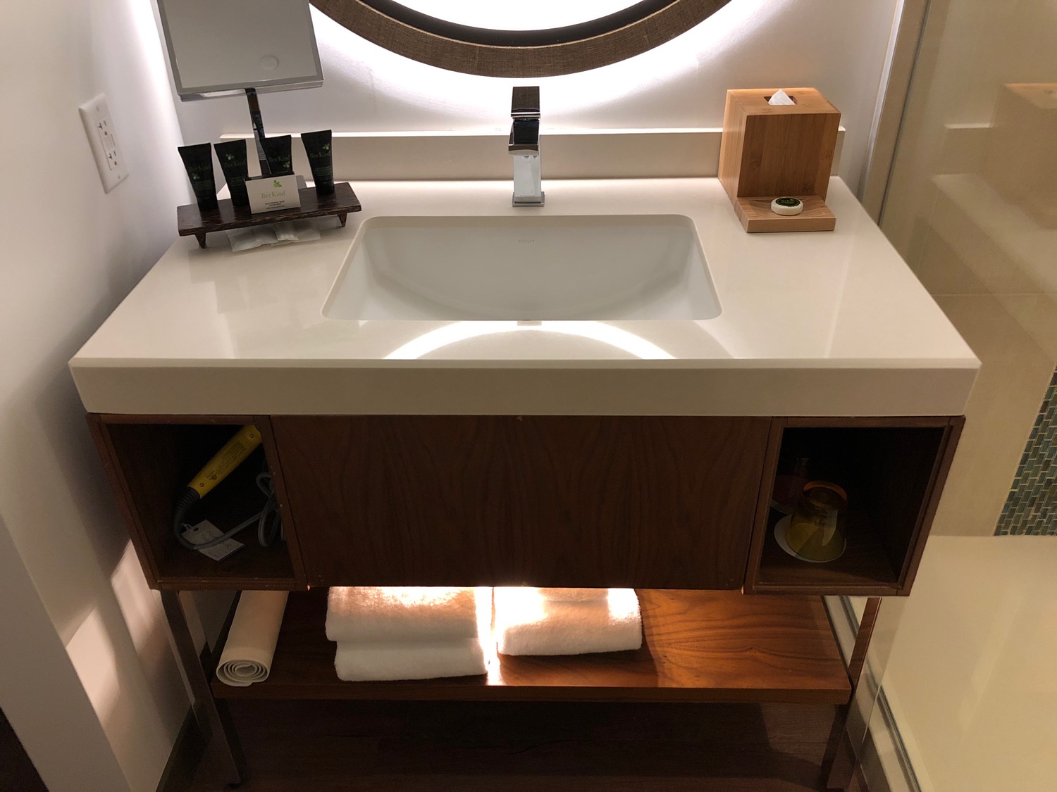 a bathroom sink with a round mirror above it