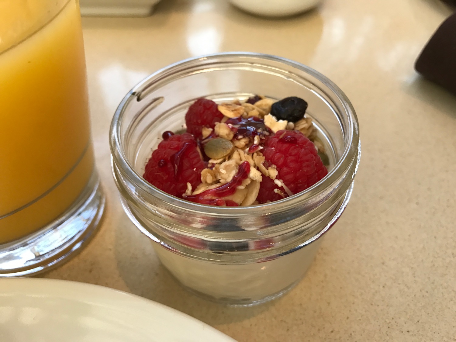 a jar of food with berries and yogurt