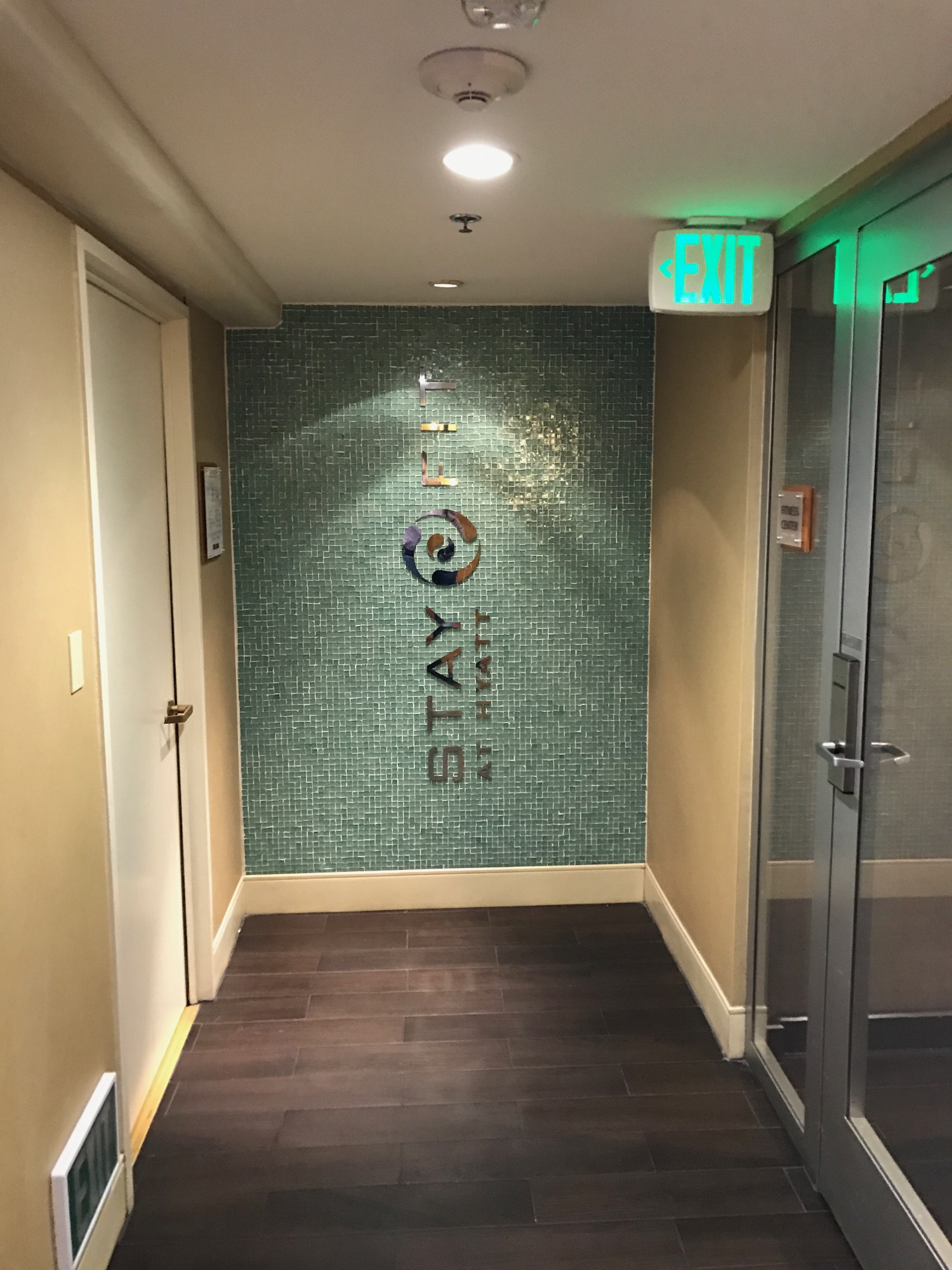 a hallway with a glass door and a sign