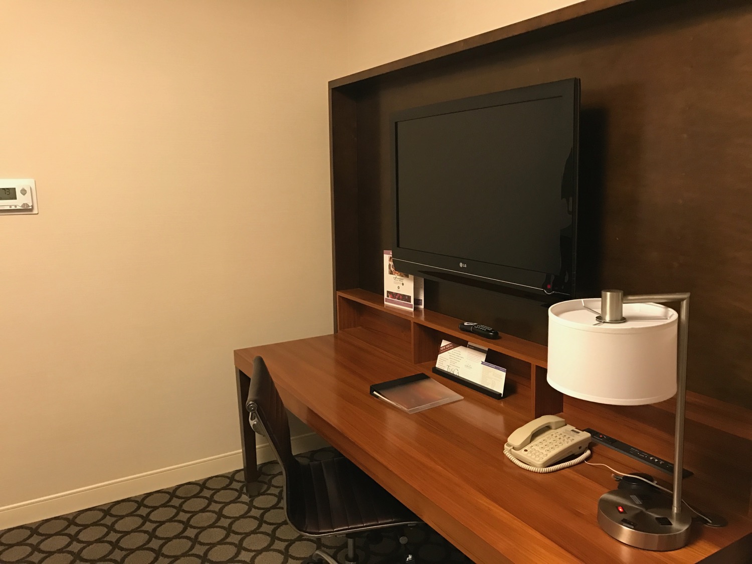 a desk with a tv and a lamp