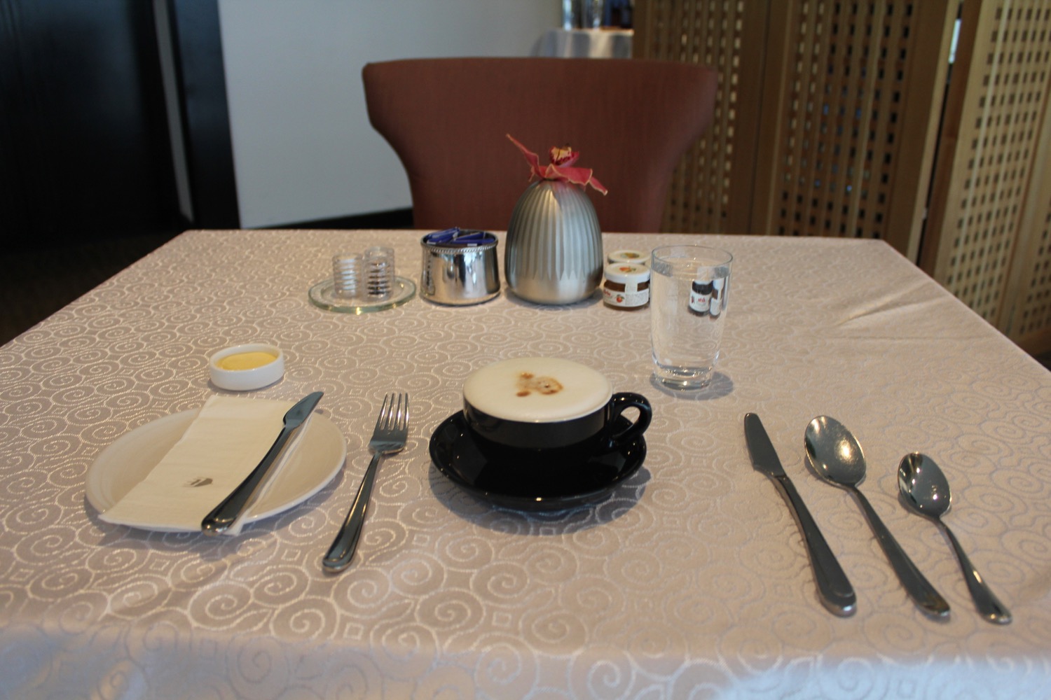 a table with a cup of coffee and utensils