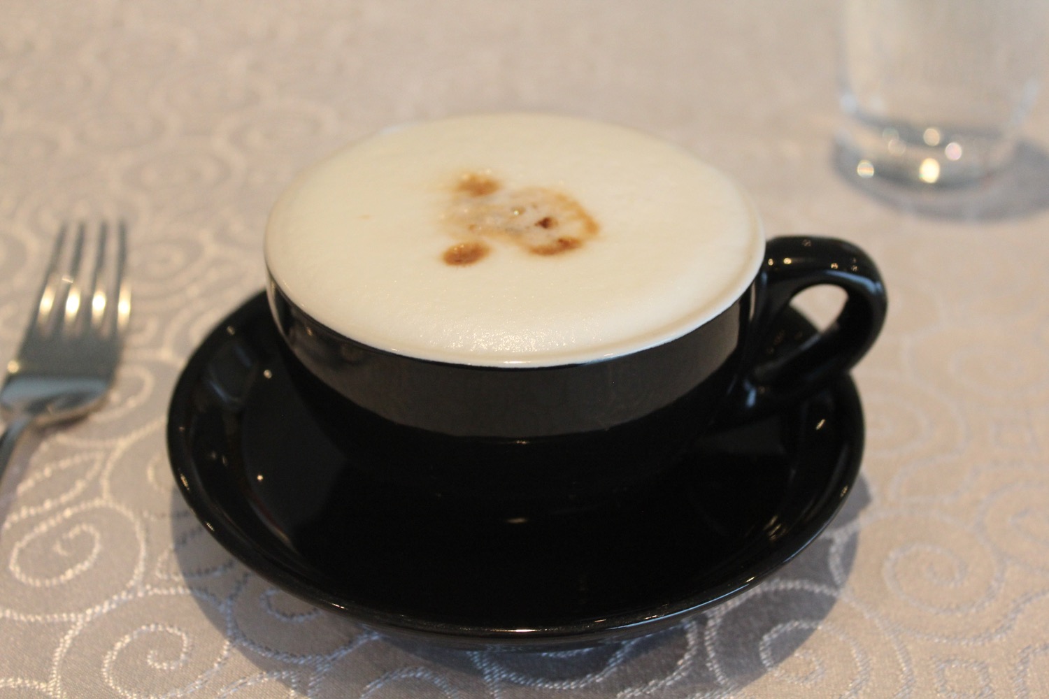 a black cup with white foam in it