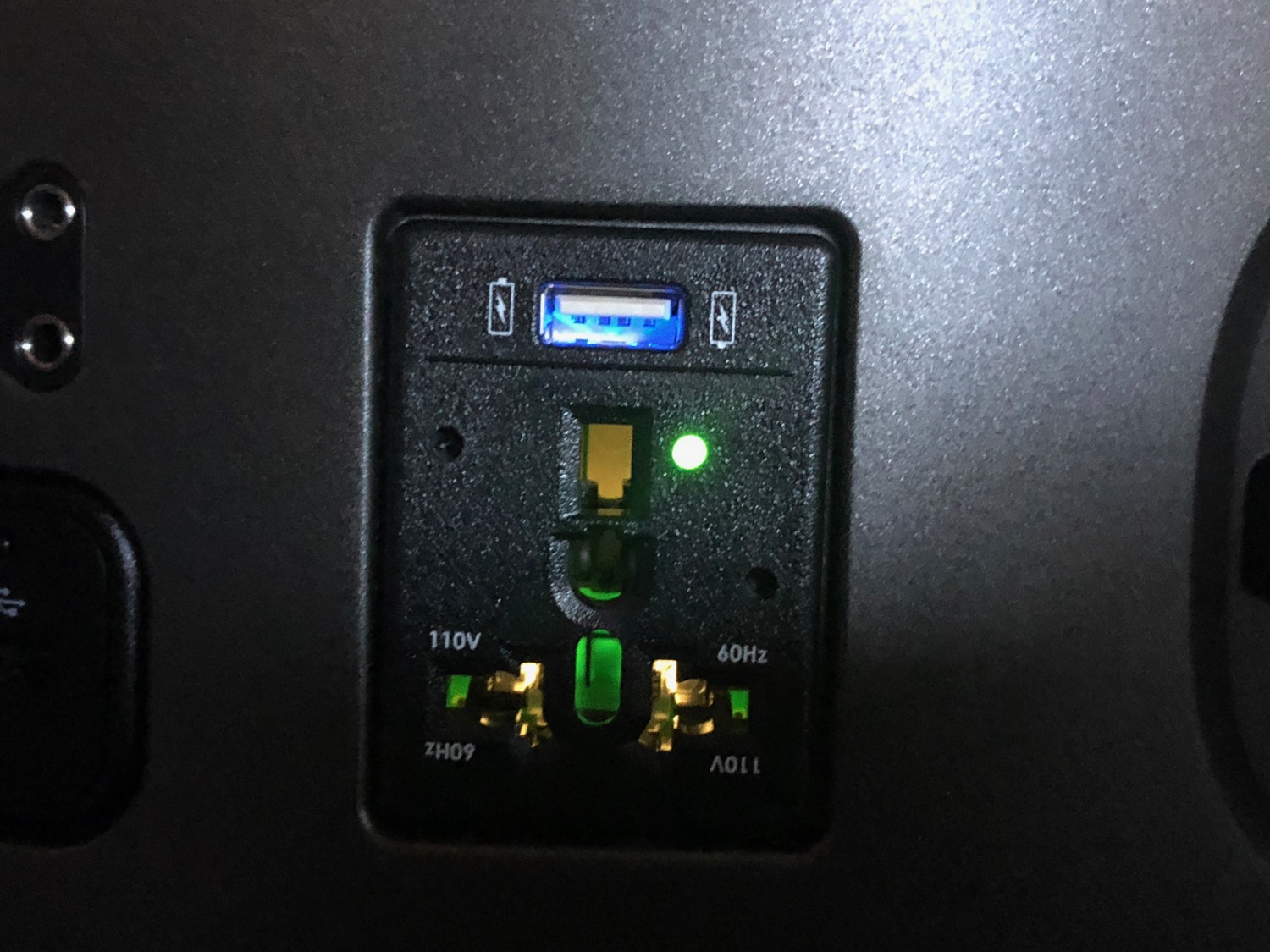 a black electrical outlet with green lights