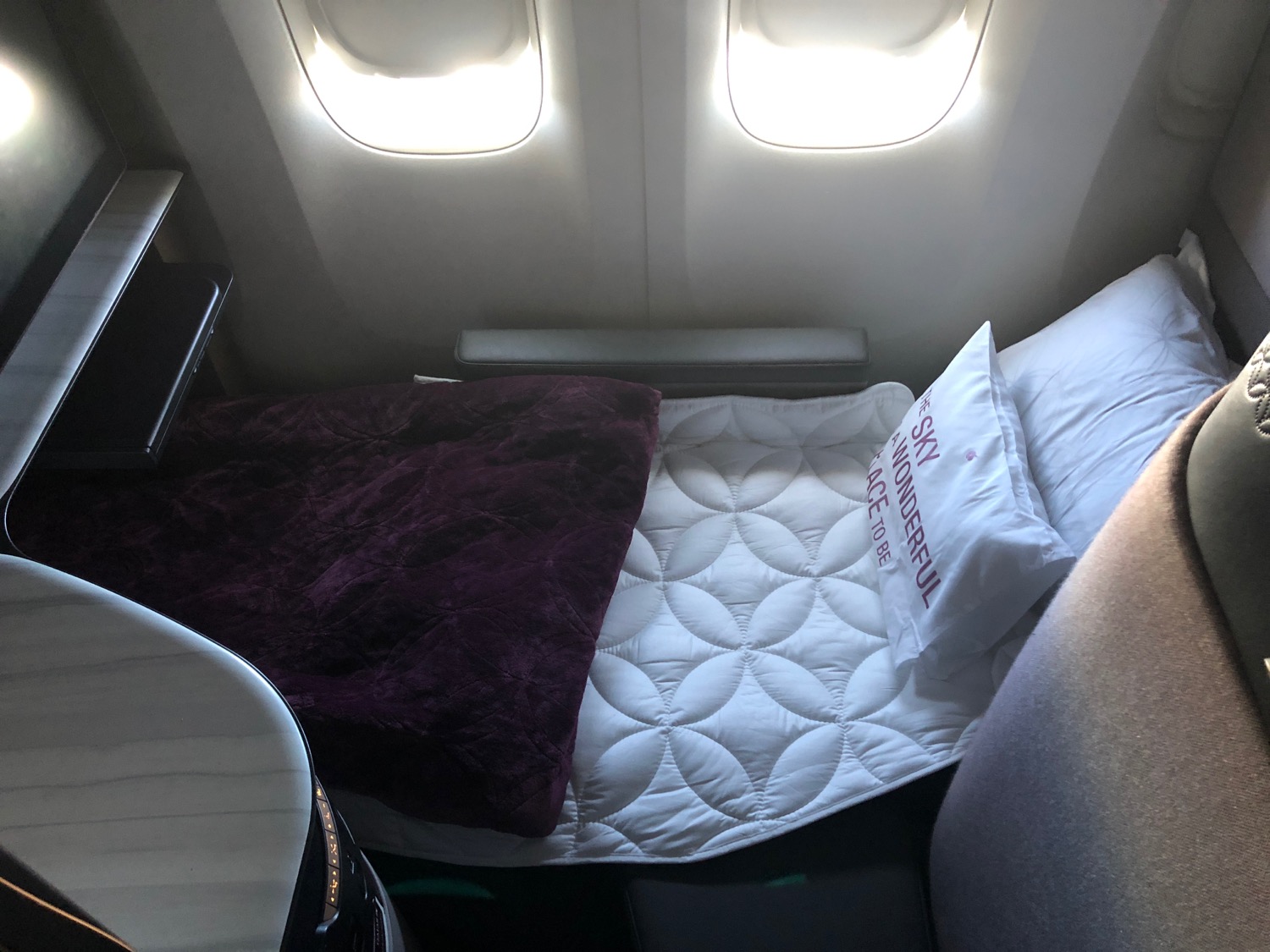 a bed with a pillow and a blanket on a plane