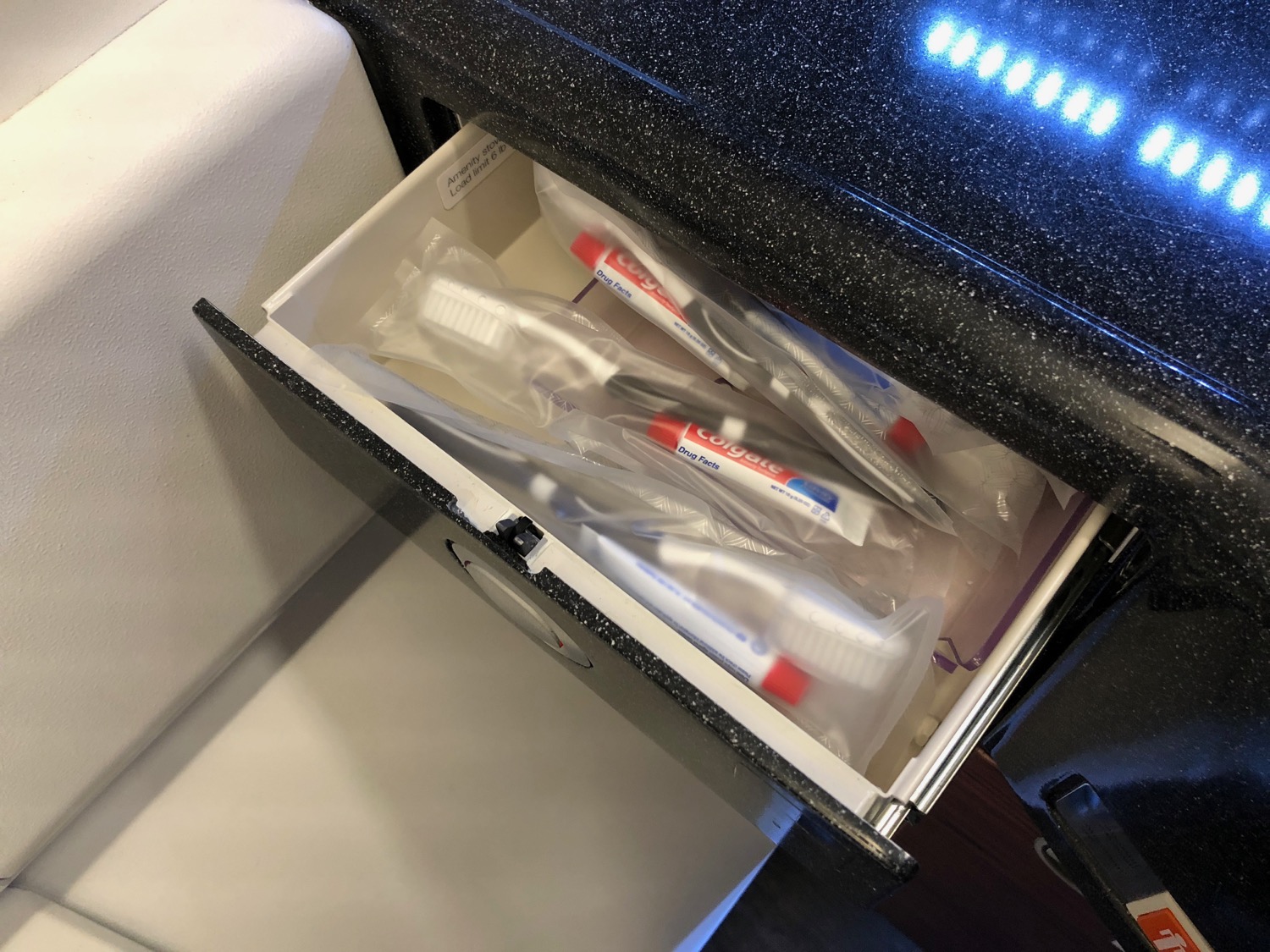 a drawer with toothbrushes and toothpaste inside
