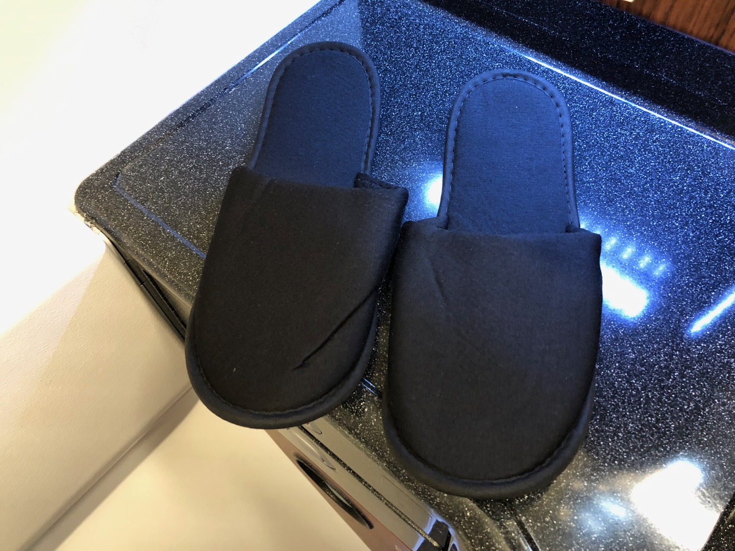a pair of black slippers on a black surface